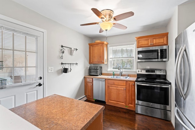 kitchen featuring dark wood-style flooring, ceiling fan, a sink, light countertops, and appliances with stainless steel finishes