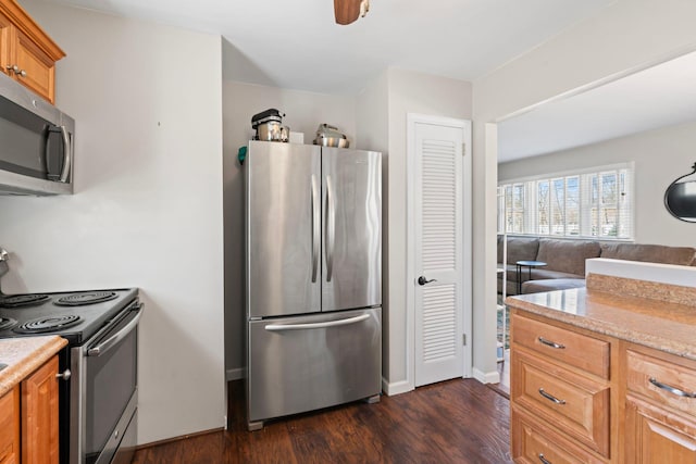 kitchen with baseboards, brown cabinets, appliances with stainless steel finishes, and dark wood-style floors