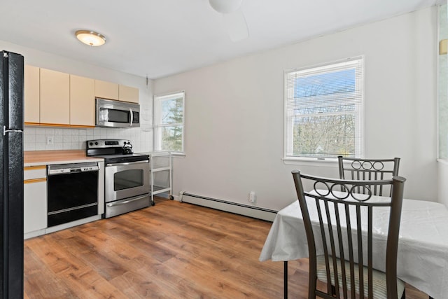 kitchen with a baseboard heating unit, light wood-type flooring, light countertops, decorative backsplash, and black appliances