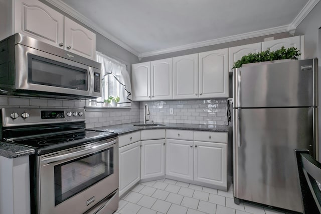 kitchen with a sink, appliances with stainless steel finishes, ornamental molding, and white cabinetry