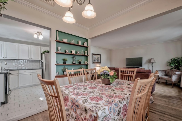 dining space with light wood-type flooring and crown molding