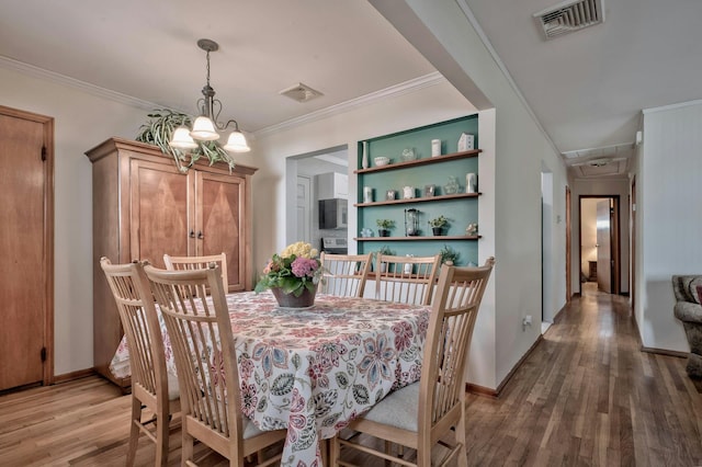 dining area featuring light wood finished floors, visible vents, a notable chandelier, and ornamental molding