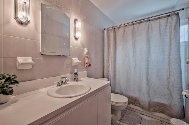 full bathroom featuring tile patterned flooring, tile walls, toilet, shower / tub combo with curtain, and vanity