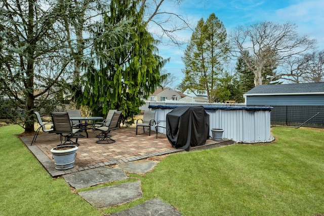 view of yard with a covered pool, fence, and a patio area