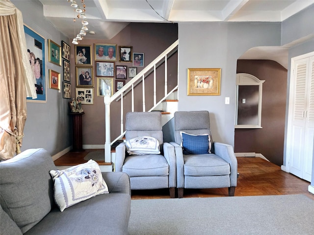 living room featuring beamed ceiling, stairway, coffered ceiling, and baseboards