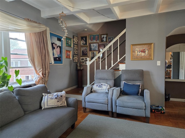 living room with stairs, beam ceiling, baseboards, and coffered ceiling