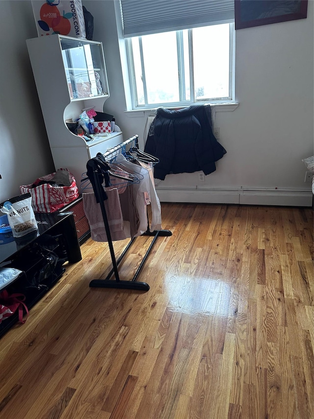 interior space featuring a baseboard heating unit and wood finished floors