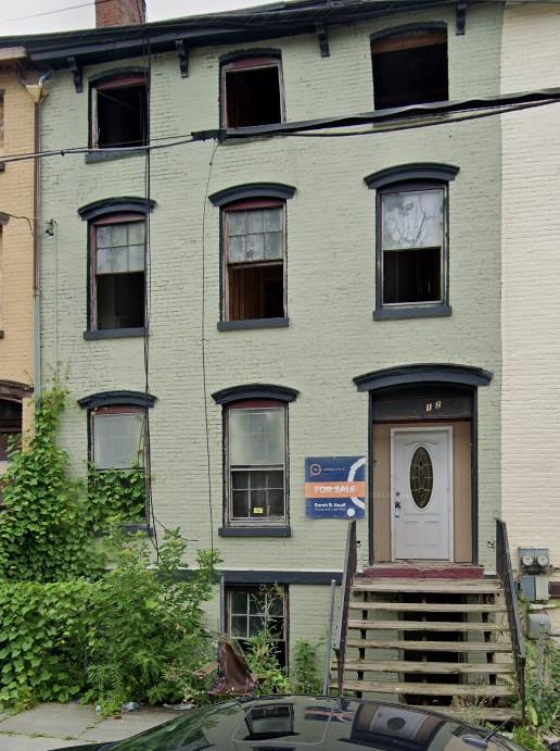 view of front of home featuring brick siding and a chimney