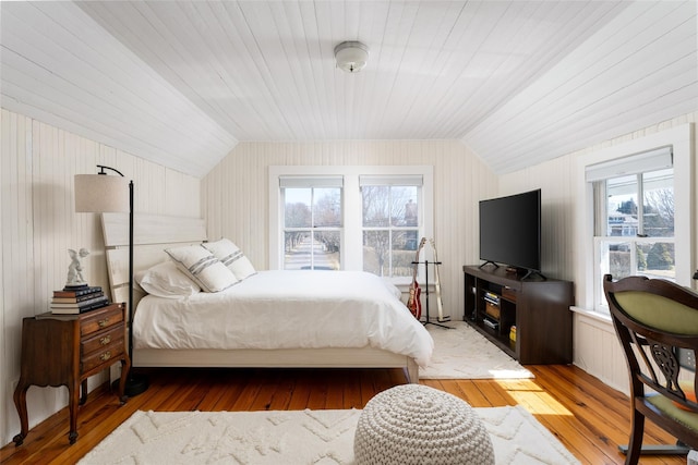 bedroom with light wood-style floors and vaulted ceiling