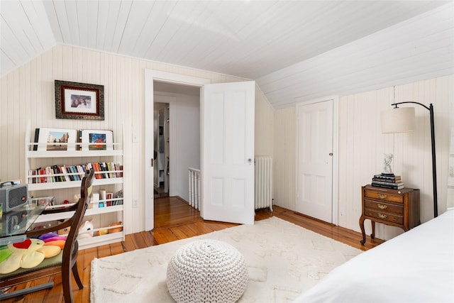 bedroom with wood ceiling, wood finished floors, radiator heating unit, and vaulted ceiling