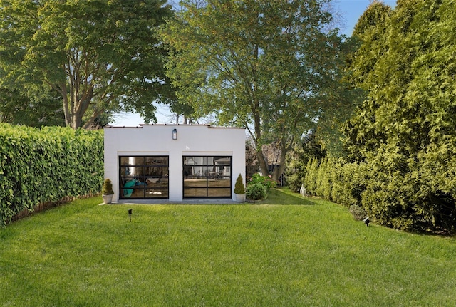 exterior space with an outbuilding, a lawn, and stucco siding