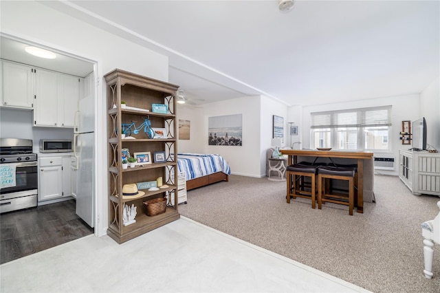 interior space featuring baseboards, dark carpet, and a wall mounted AC