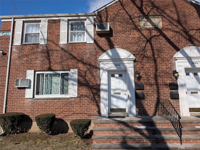 doorway to property with brick siding