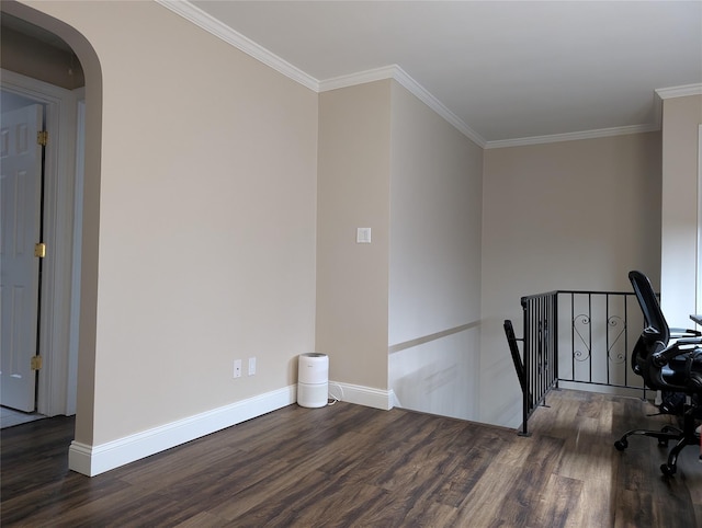 home office featuring baseboards, arched walkways, wood finished floors, and ornamental molding