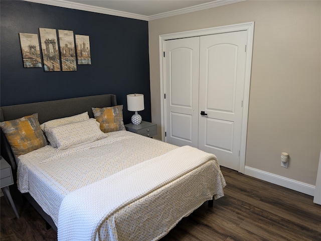 bedroom featuring baseboards, wood finished floors, a closet, and ornamental molding