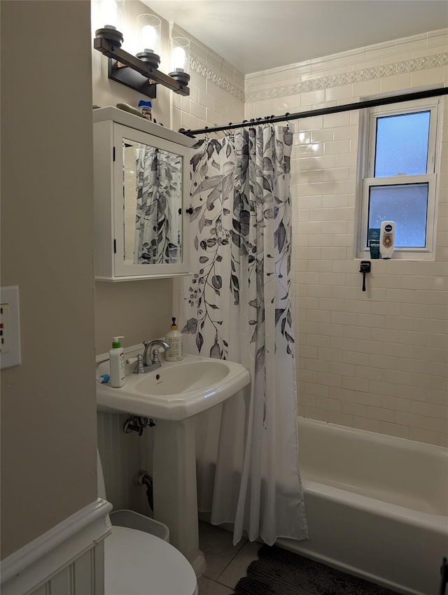 bathroom with a sink, toilet, and shower / bath combo