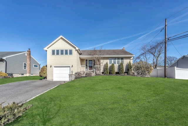 view of front of property with driveway, an attached garage, a front yard, and fence