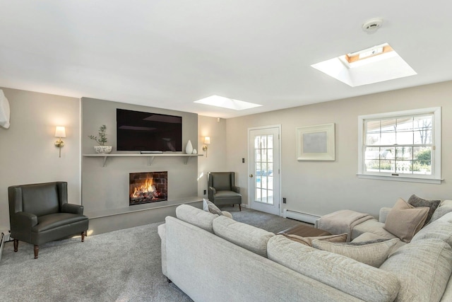 living room featuring a baseboard heating unit, a lit fireplace, and carpet floors