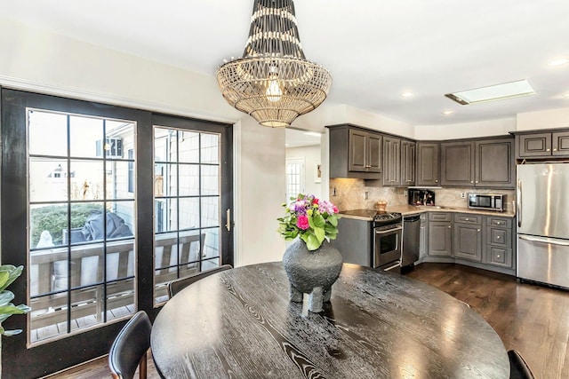 kitchen featuring backsplash, light countertops, recessed lighting, appliances with stainless steel finishes, and dark wood-style flooring