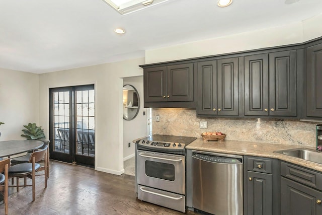 kitchen with stainless steel appliances, dark wood finished floors, decorative backsplash, and light countertops