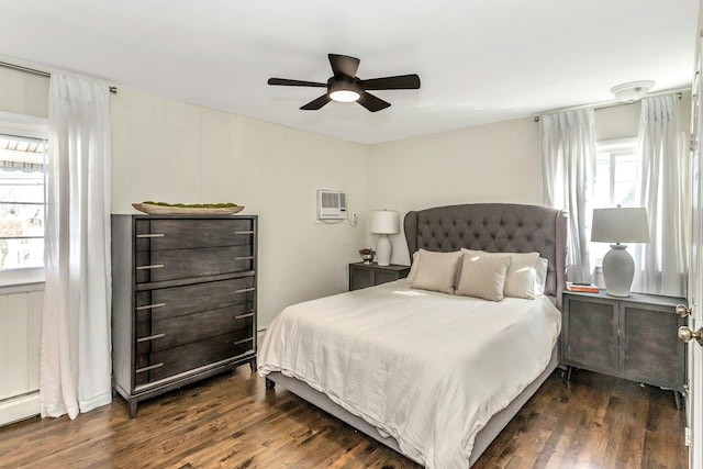 bedroom with dark wood-style floors, multiple windows, and a ceiling fan