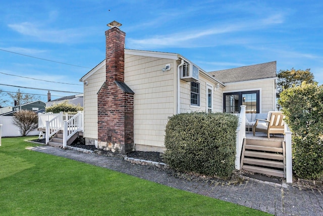 view of side of home featuring a chimney, a wooden deck, a yard, and roof with shingles