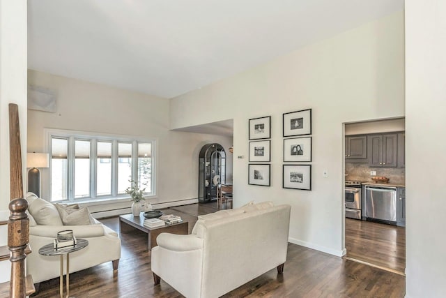 living area featuring dark wood-style floors, arched walkways, a baseboard radiator, baseboards, and baseboard heating