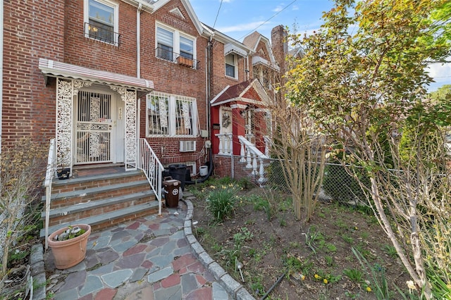 view of front of house with brick siding and fence