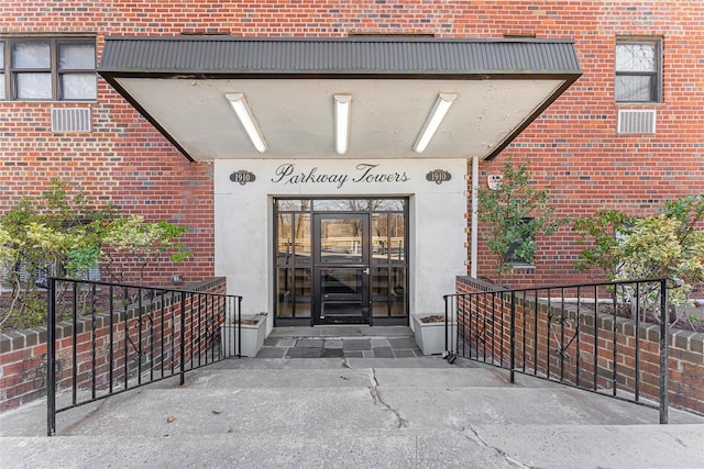 view of exterior entry featuring brick siding