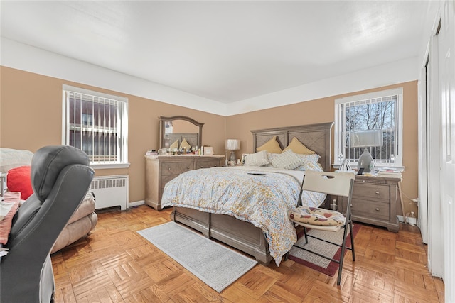 bedroom with baseboards and radiator