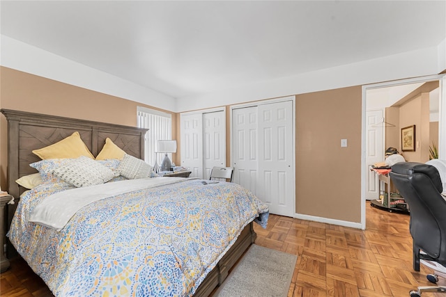 bedroom featuring baseboards and multiple closets