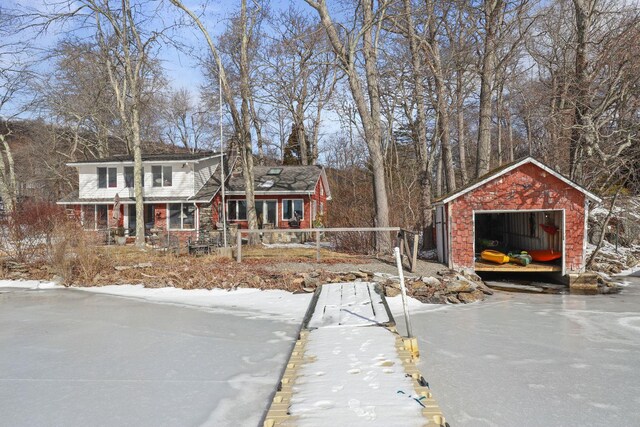 view of front of property with an outbuilding, a garage, brick siding, and covered porch