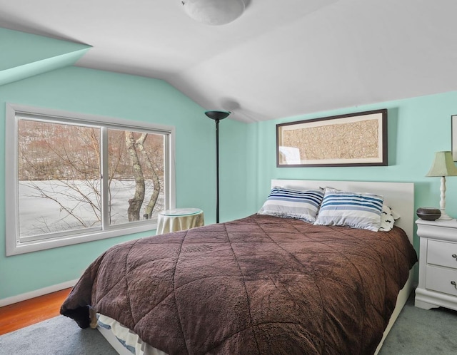 bedroom with wood finished floors, baseboards, and vaulted ceiling