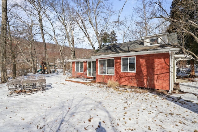 snow covered property with a playground