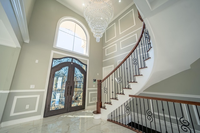 entryway featuring a notable chandelier, french doors, marble finish floor, and a healthy amount of sunlight