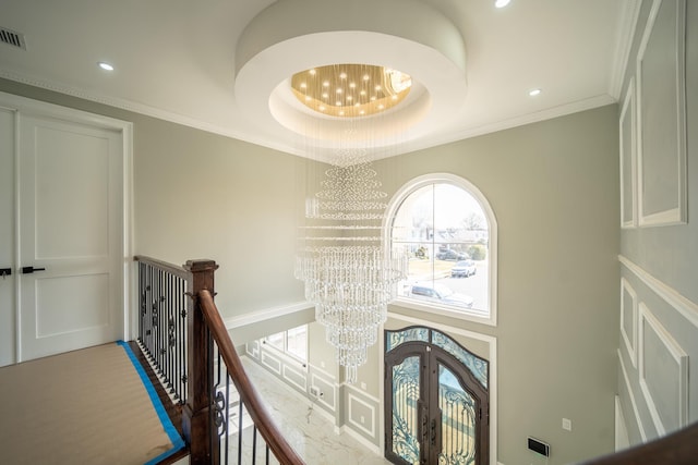 hallway featuring crown molding, an upstairs landing, recessed lighting, french doors, and a notable chandelier