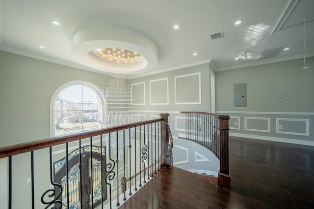 corridor with visible vents, an upstairs landing, electric panel, a decorative wall, and attic access