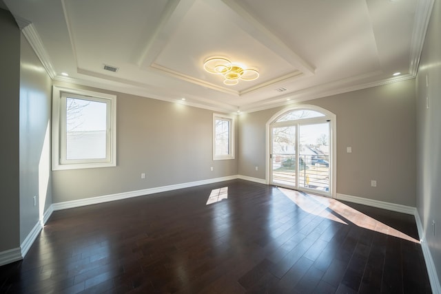 spare room with a tray ceiling, baseboards, visible vents, and dark wood-style flooring