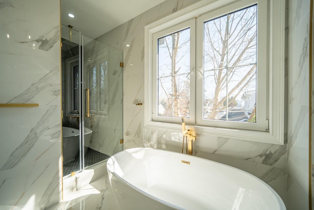 full bath featuring a marble finish shower, a soaking tub, a healthy amount of sunlight, and recessed lighting