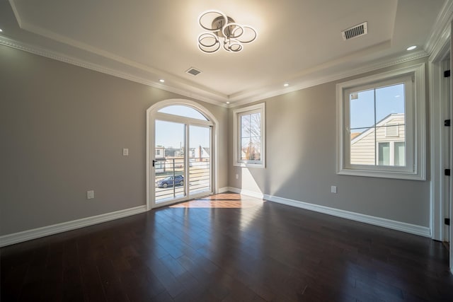 unfurnished room with baseboards, visible vents, dark wood-style flooring, and ornamental molding