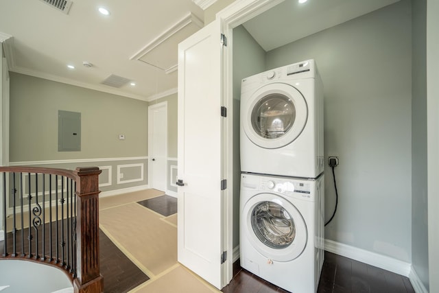 washroom with dark wood finished floors, attic access, stacked washer and dryer, and laundry area