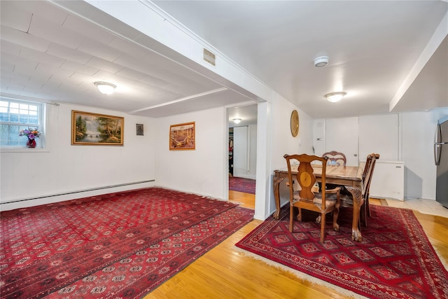 dining room with visible vents, wood finished floors, and a baseboard radiator