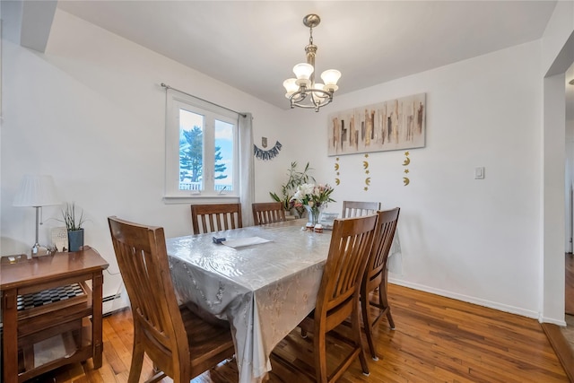 dining room with hardwood / wood-style floors, baseboards, and a chandelier