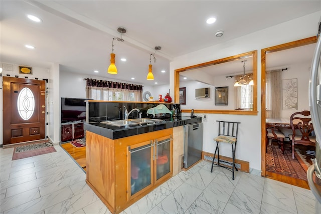 kitchen featuring dark countertops, marble finish floor, dishwasher, and a sink