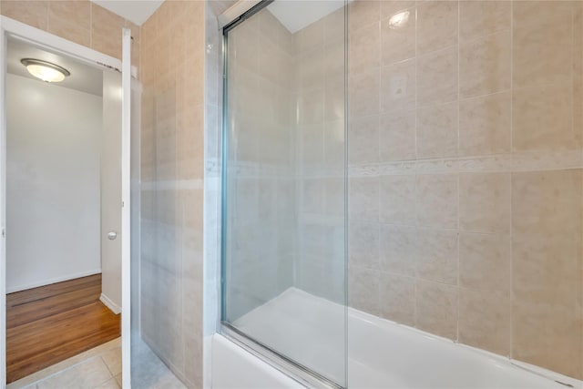 bathroom featuring enclosed tub / shower combo and tile patterned flooring