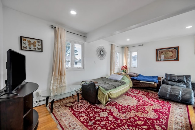 bedroom featuring light wood-type flooring, a baseboard radiator, and recessed lighting