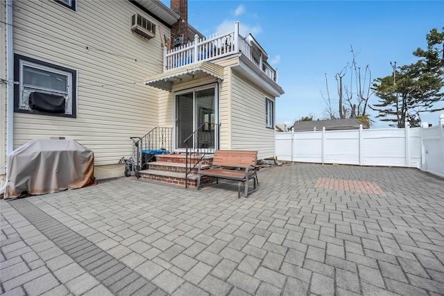 view of patio / terrace featuring area for grilling, a wall mounted AC, a balcony, and fence