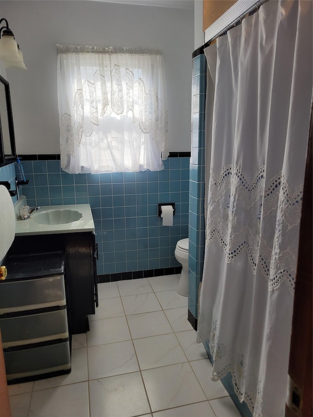 full bathroom with a wainscoted wall, toilet, a shower with shower curtain, tile walls, and vanity