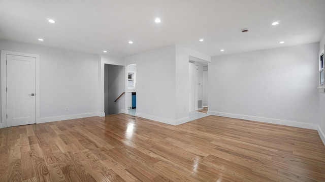 empty room featuring recessed lighting, baseboards, and light wood finished floors