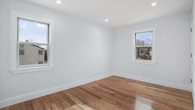 empty room featuring recessed lighting, baseboards, and light wood-type flooring